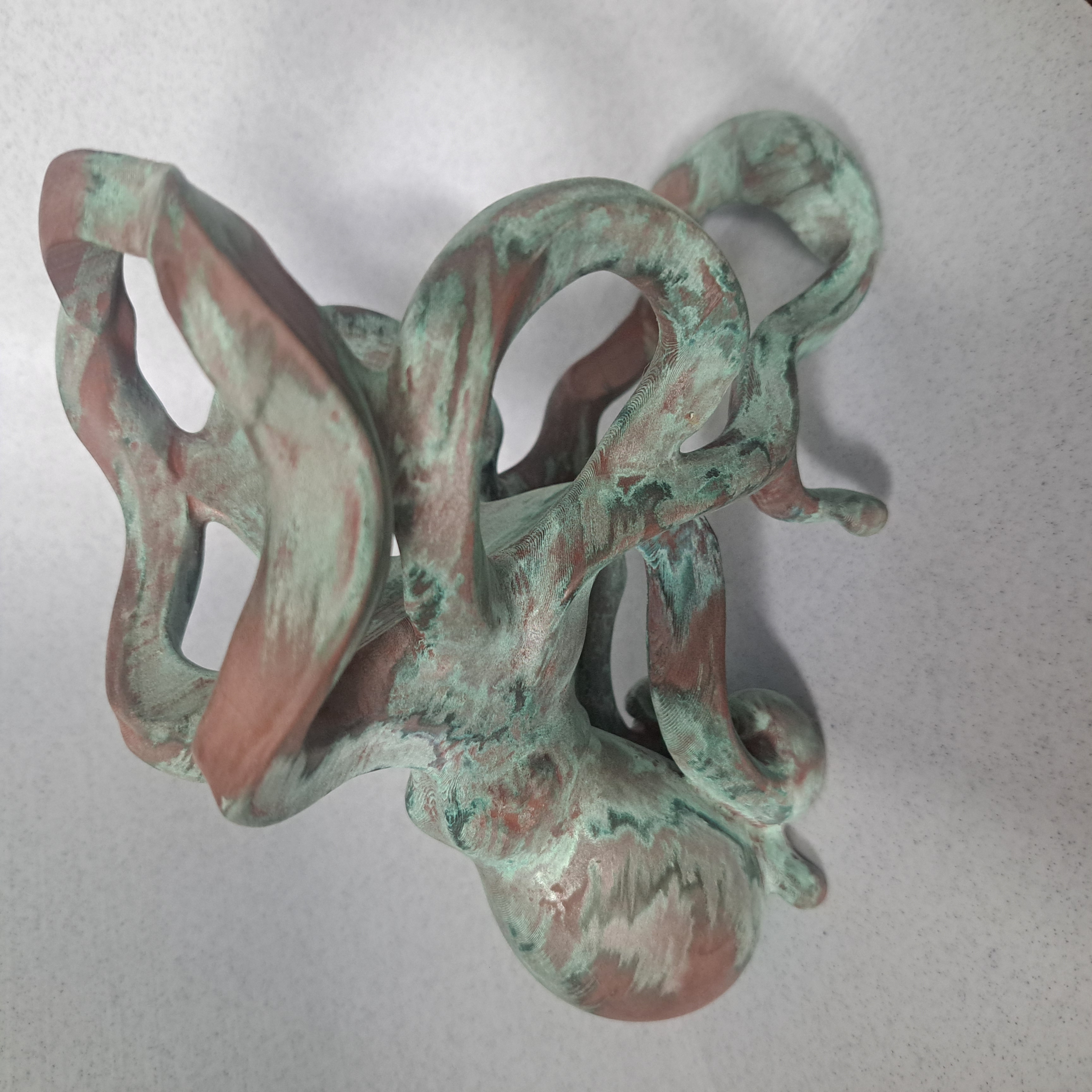 Top view of octopus holder showing patina variation across tentacle loops